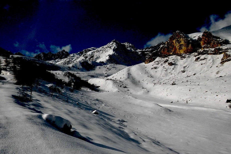 Pianoro imbiancato dalla neve, sullo sfondo le punte delle montagne