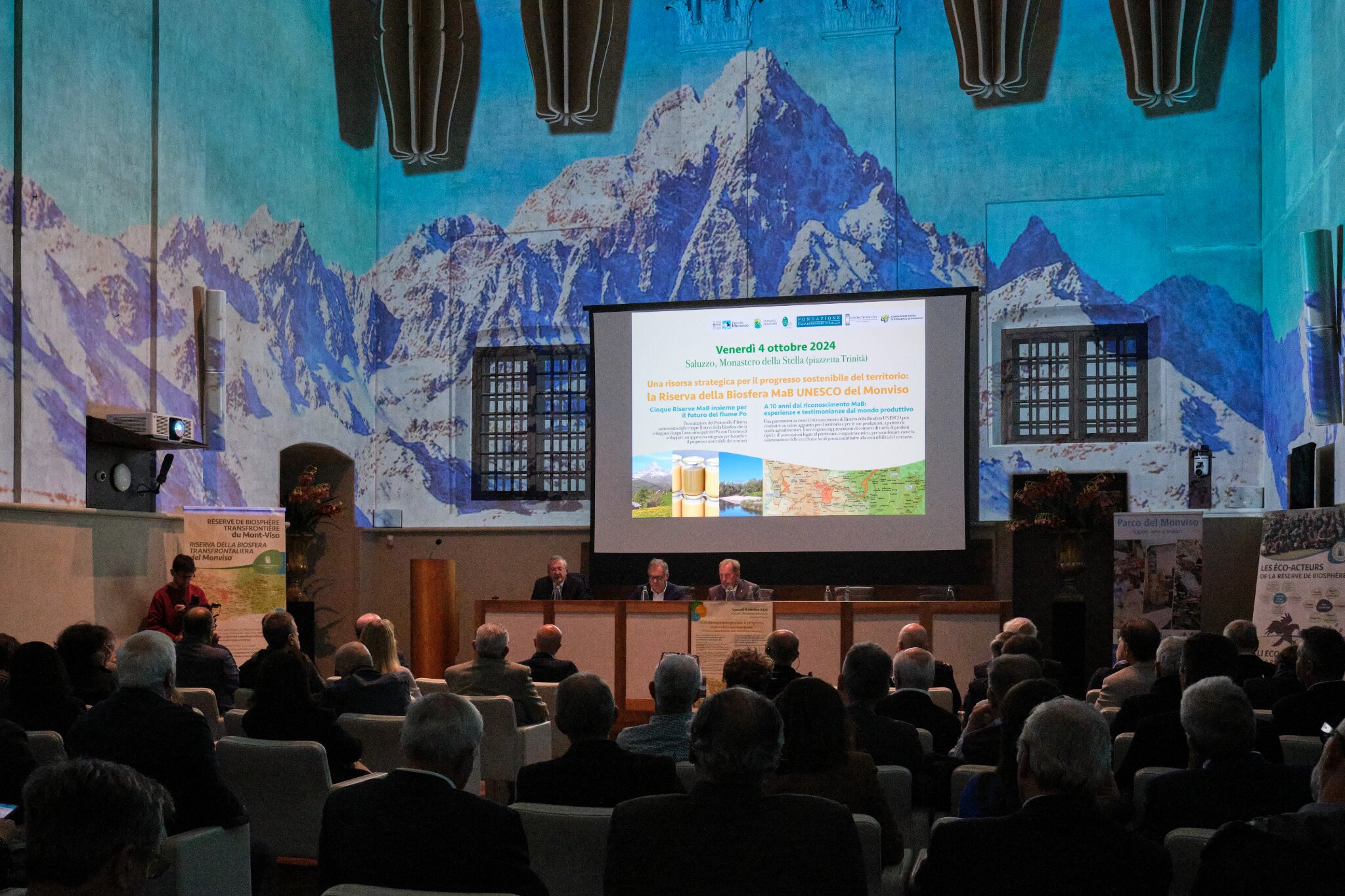 la platea dell'evento, con il palco con alcuni relatori