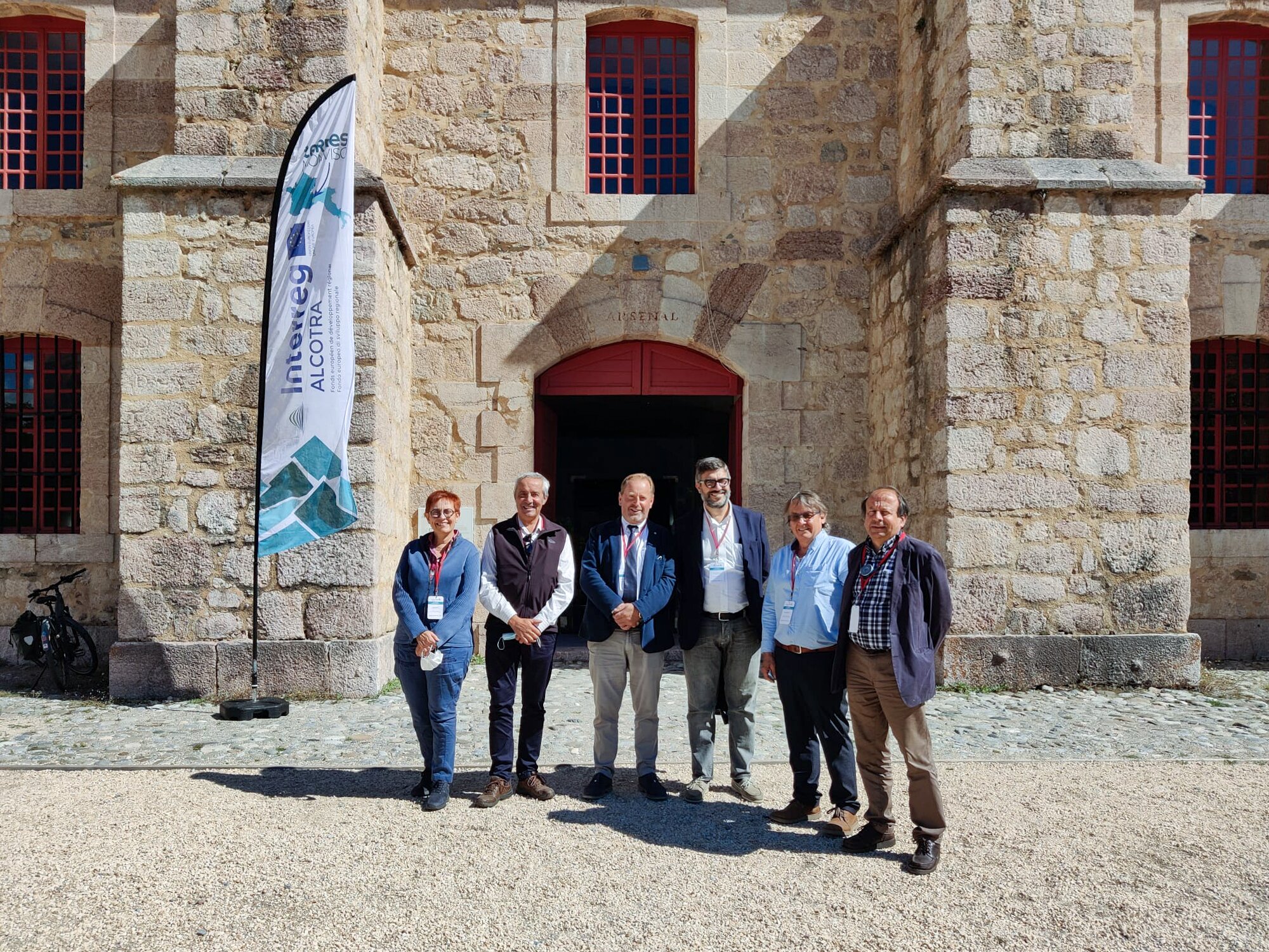 Sei persone davanti all'ingresso della cittadella fortificata di Mont-Dauphin: il presidente del Parco del Monviso con il sindaco di Mont-Dauphin, i presidenti della Communauté de communes du Guillestrois et du Queyras e del Parc naturel régional du Queyras e il sindaco di Saluzzo