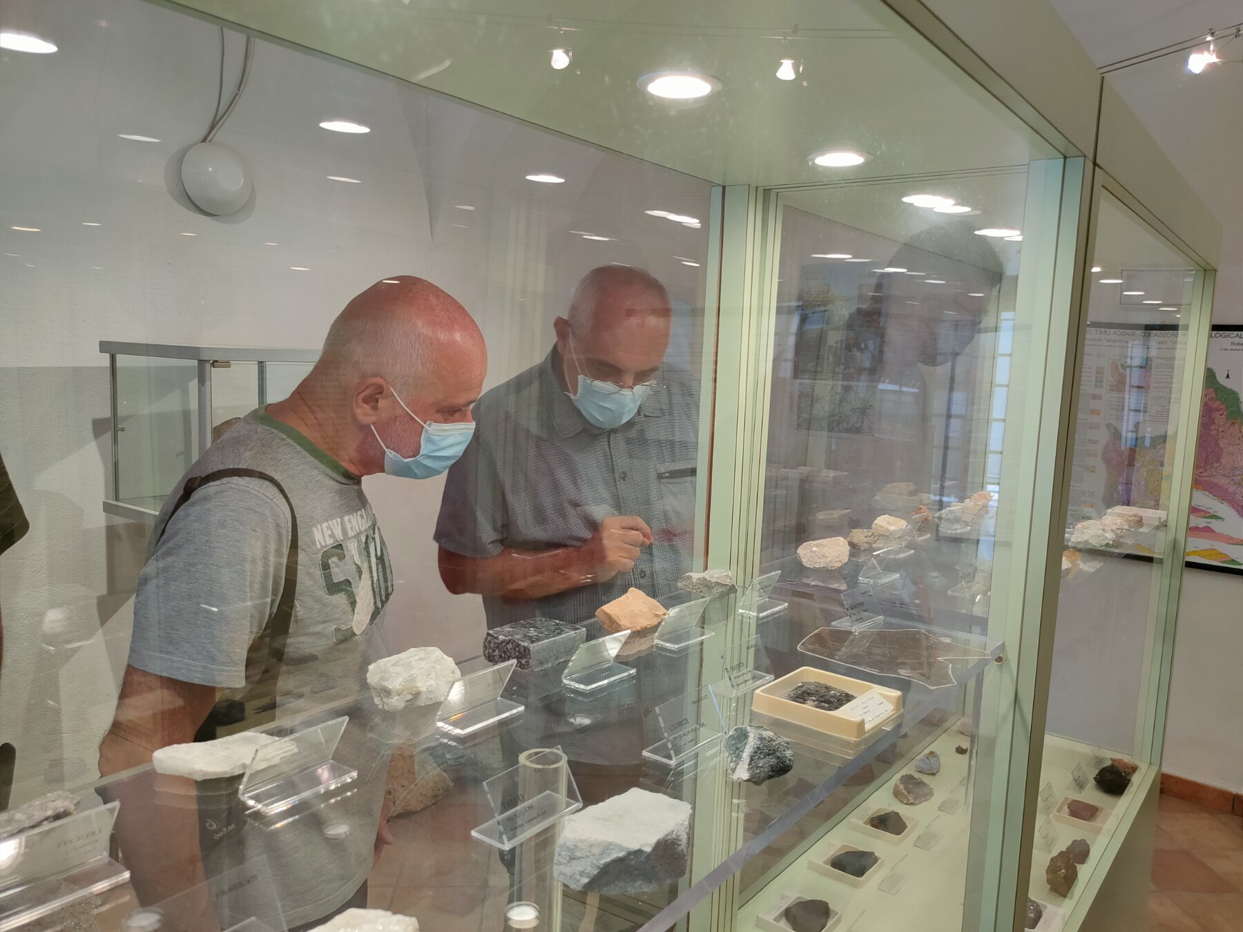 Due persone in visita al Museo del Piropo di Martiniana Po mentre guardano una vetrina contenente minerali.