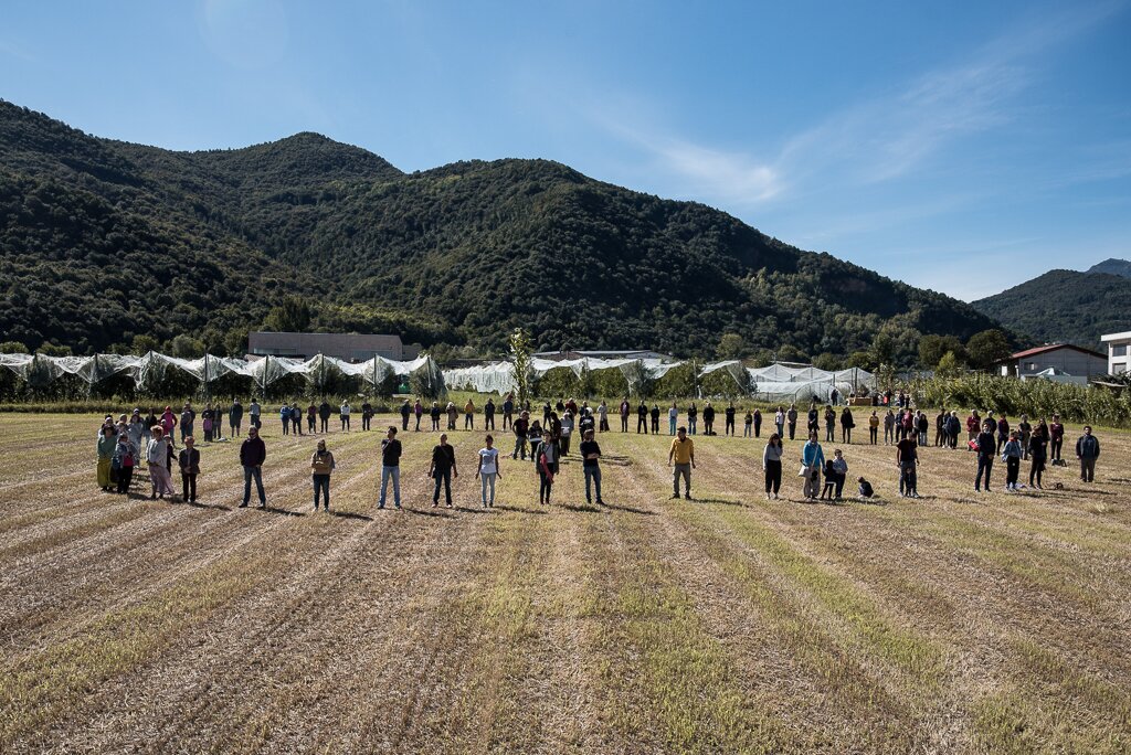 un gruppo di numerose persone disposte a cerchio in una campo