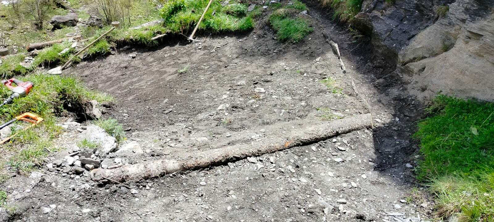 un tratto di sentiero nel quale si vede, sul lato destro, una canalina di scolo delle acque scavata nel terreno