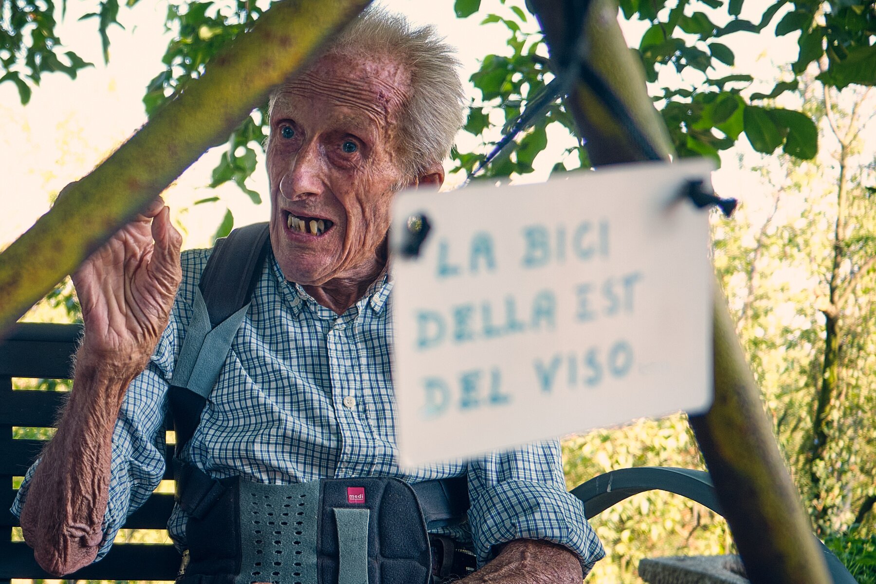 In primo piano si vede, anche se sfocata per scelta fotografica, una parte del telaio della bicicletta, con un cartellino appeso su cui si legge 
