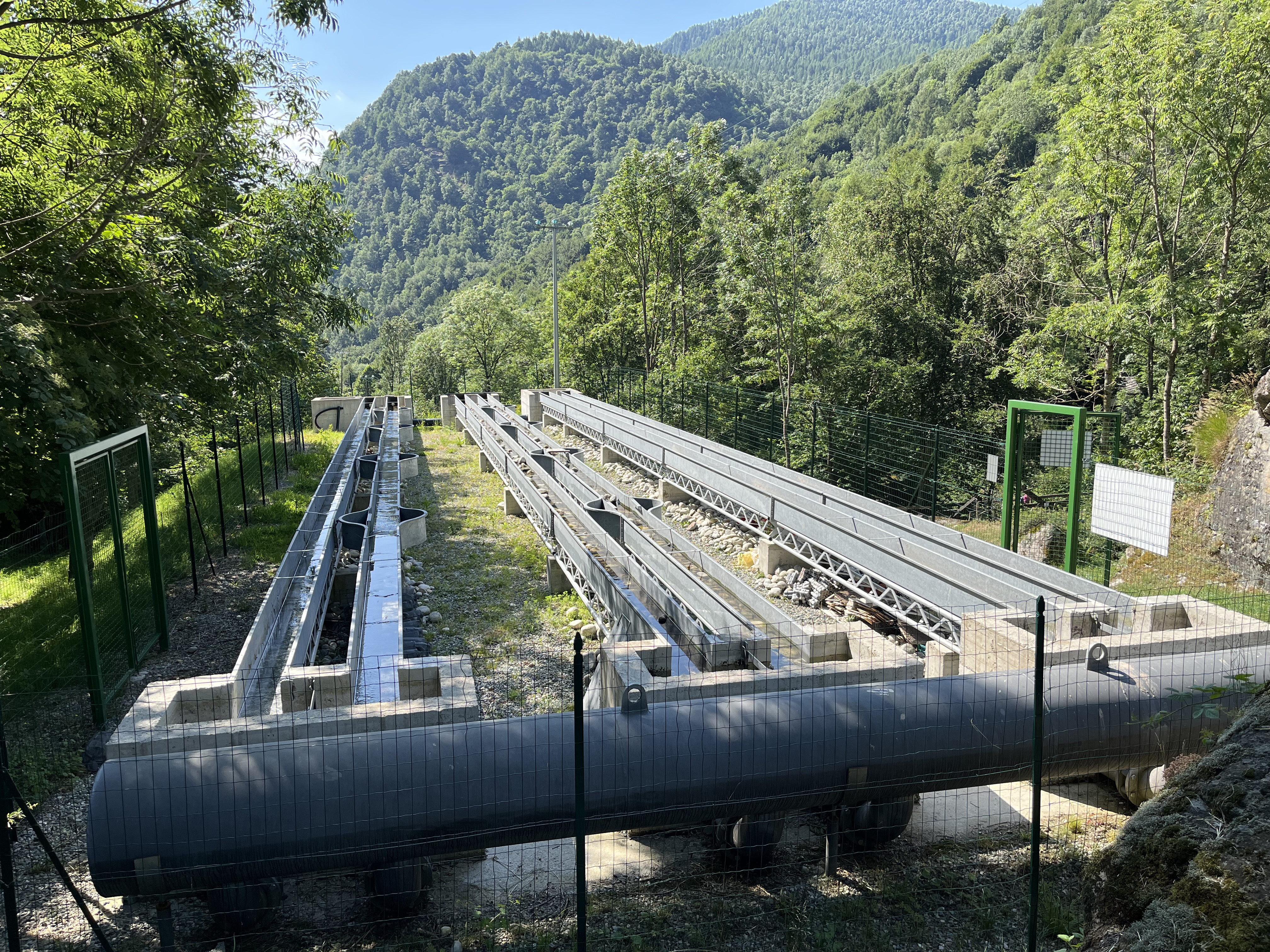 le canalette del Centro ALPSTREAM: strutture in metallo immerse in un ambiente boschivo