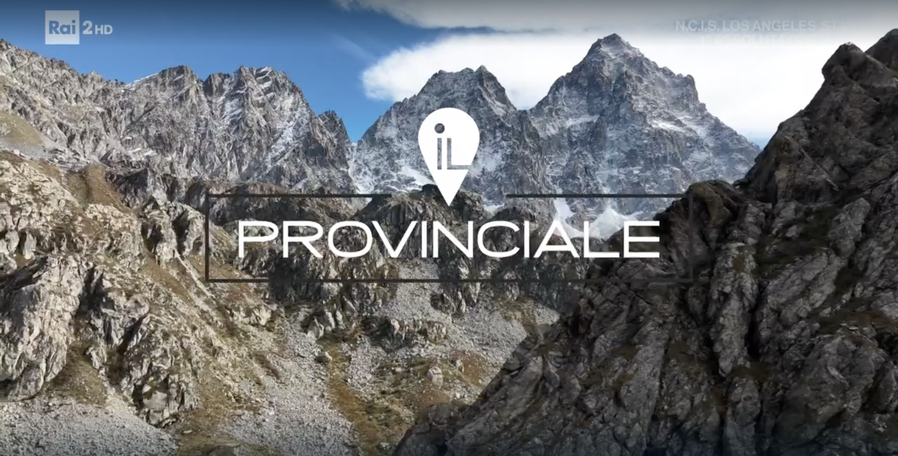 immagine da drone che inquadra il Monviso al centro, circondato dalle altre cime intorno. C'è una leggera spruzzata di neve, poiché la ripresa è stata effettuata a ottobre. In sovrimpressione, il logo della trasmissione di Rai2 Il Provinciale.