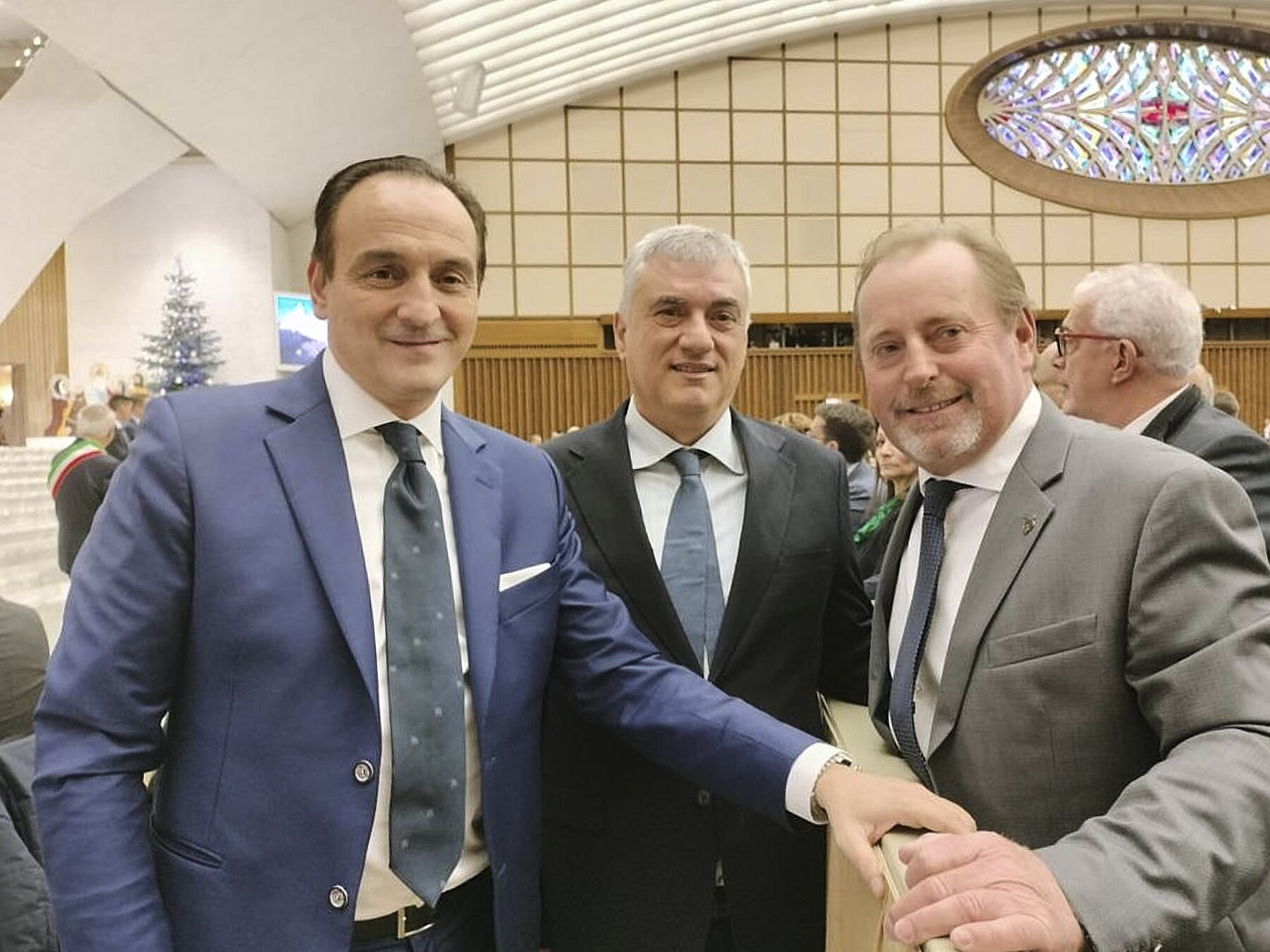 Tre persone in primo piano: il presidente della Regione Piemonte e il presidente della Riserva della Biosfera transfrontaliera del Monviso si incontrano nella sala Paolo VI in Vaticano, con loro anche il presidente della Riserva MaB Unesco del Monte Peglia, al centro nella foto.