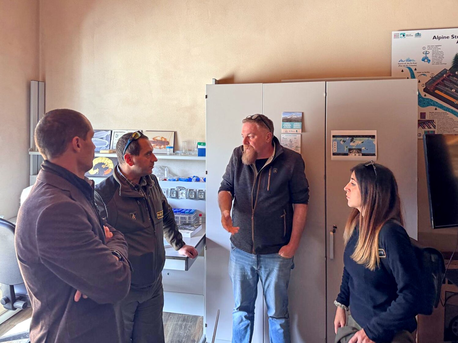 quattro persone stanno parlando in un ambiente interno, una sala dedicata allo studio scientifico.
