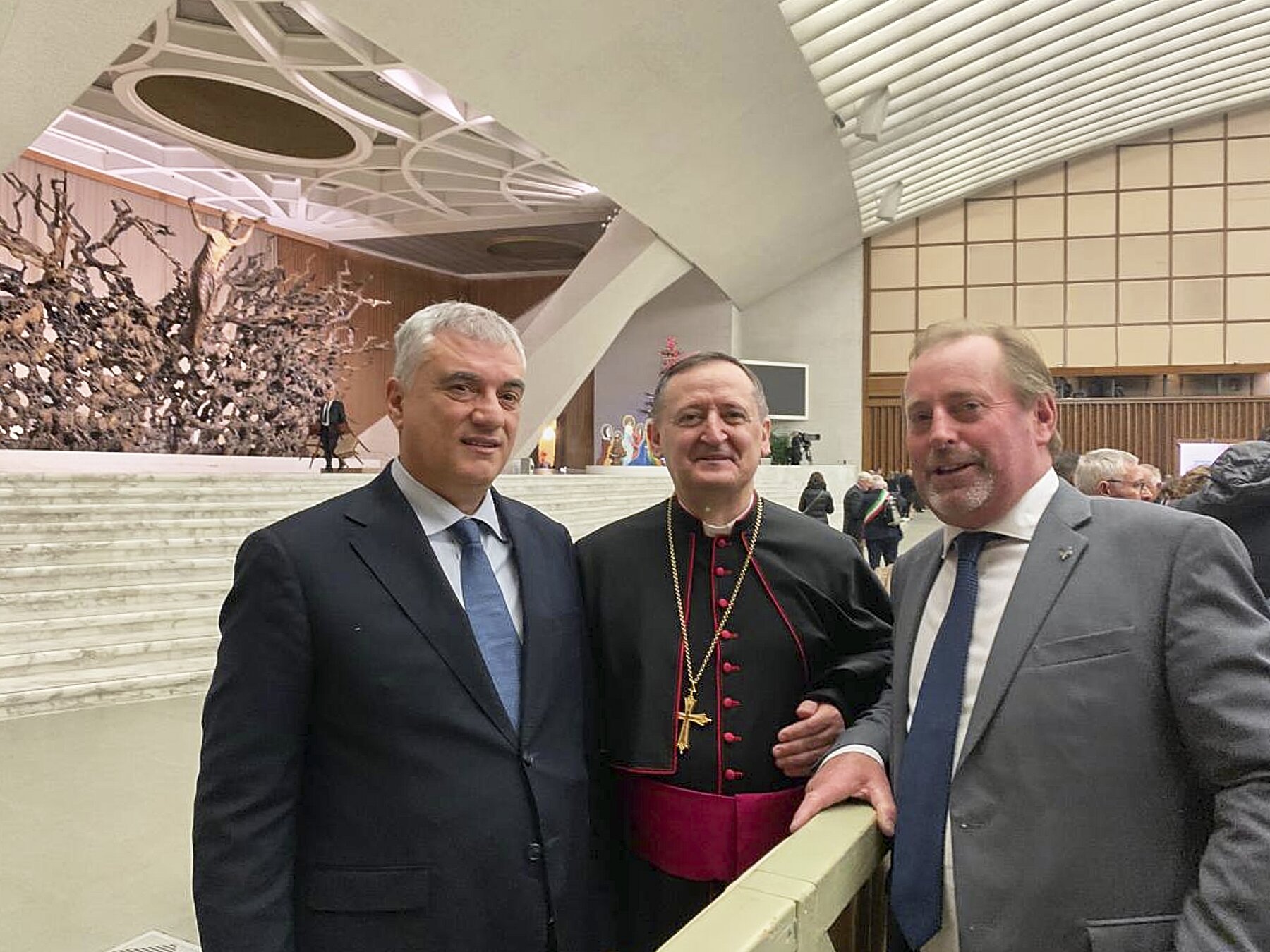 Tre persone in primo piano: al centro c'è il vescovo di Saluzzo e ai suoi lati i due presidenti delle Riserve MaB Unesco del Monte Peglia, a sinistra, e del Monviso, a destra. Sullo sfondo si riconosce la sala Paolo VI in Vaticano.