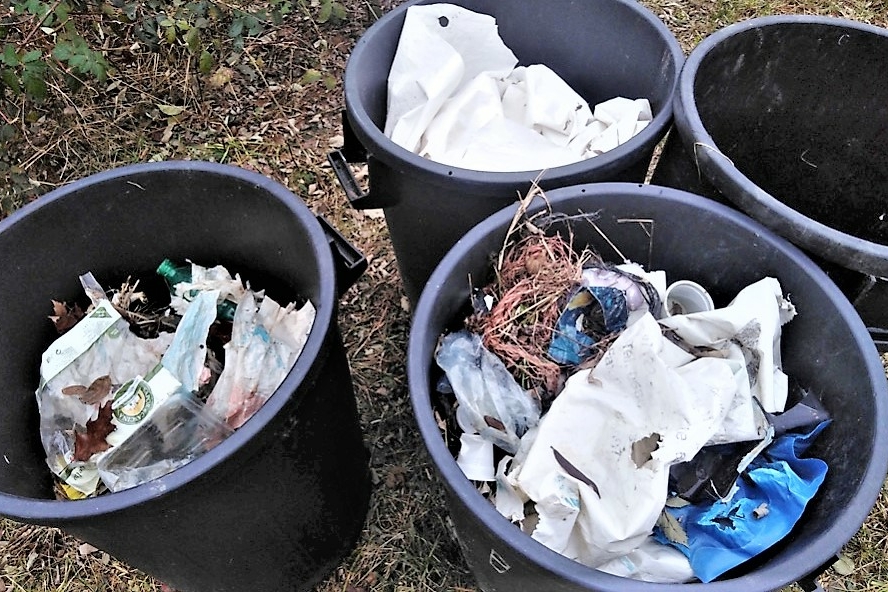 quattro bidoni della spazzatura pieni di rifiuti