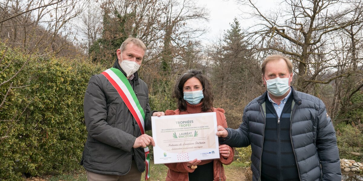 Il Presidente del Parco del Monviso, Dario Miretti, e il Sindaco di Rossana, Giuliano Degiovanni, consegnano il premio a Stefania Larovere. Tutti e tre indossano la mascherina causa covid-19.