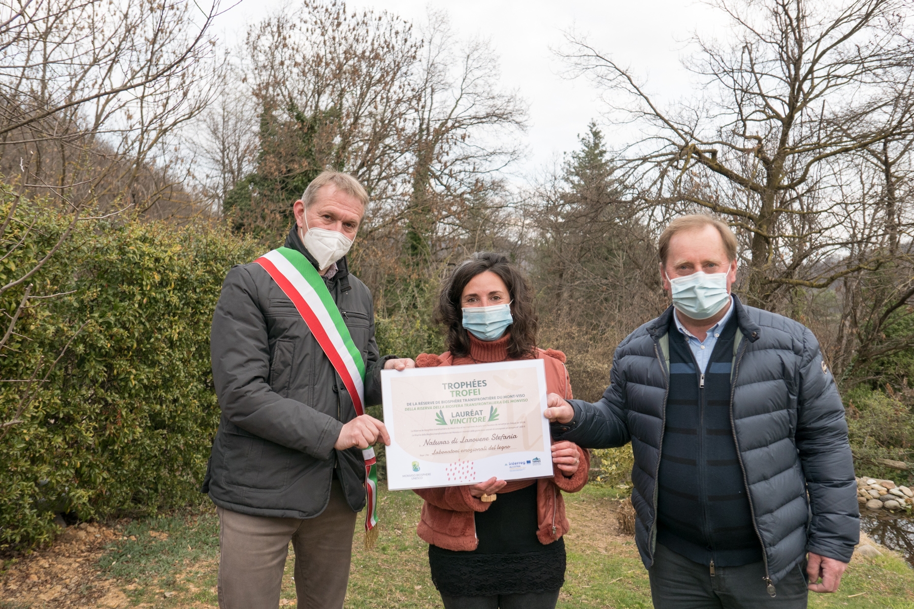 Il Presidente del Parco del Monviso, Dario Miretti, e il Sindaco di Rossana, Giuliano Degiovanni, consegnano il premio a Stefania Larovere. Tutti e tre indossano la mascherina causa covid-19.