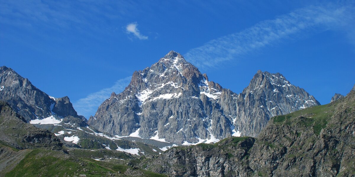 immagine del Monviso e del Visolotto spruzzati di neve. sullo sfondo cielo azzurro con striature di nuvole