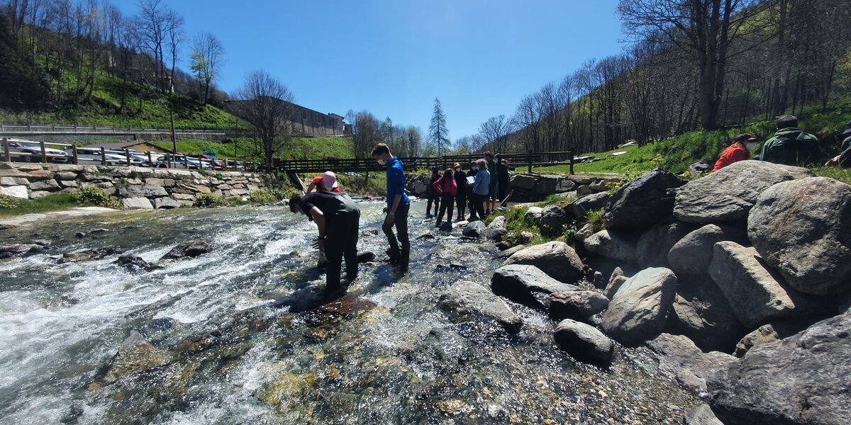 gruppo di studenti dentro il fiume Po in contesto alpino