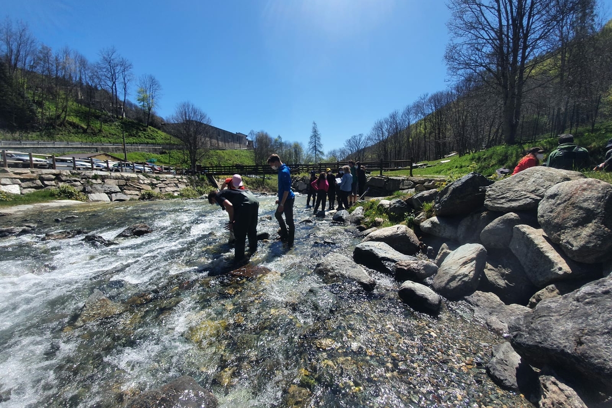gruppo di studenti dentro il fiume Po in contesto alpino