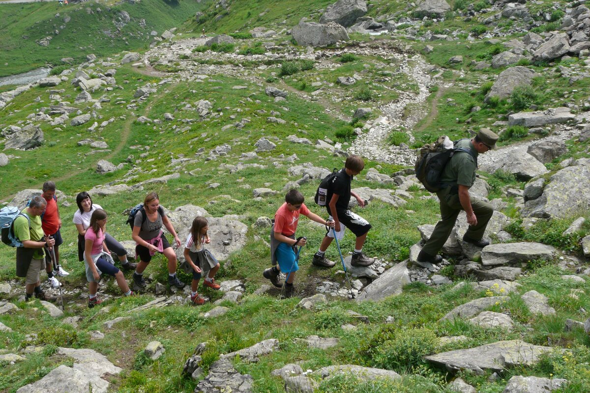 Un guardiaparco guida un gruppo di escursionisti su un sentiero in montagna
