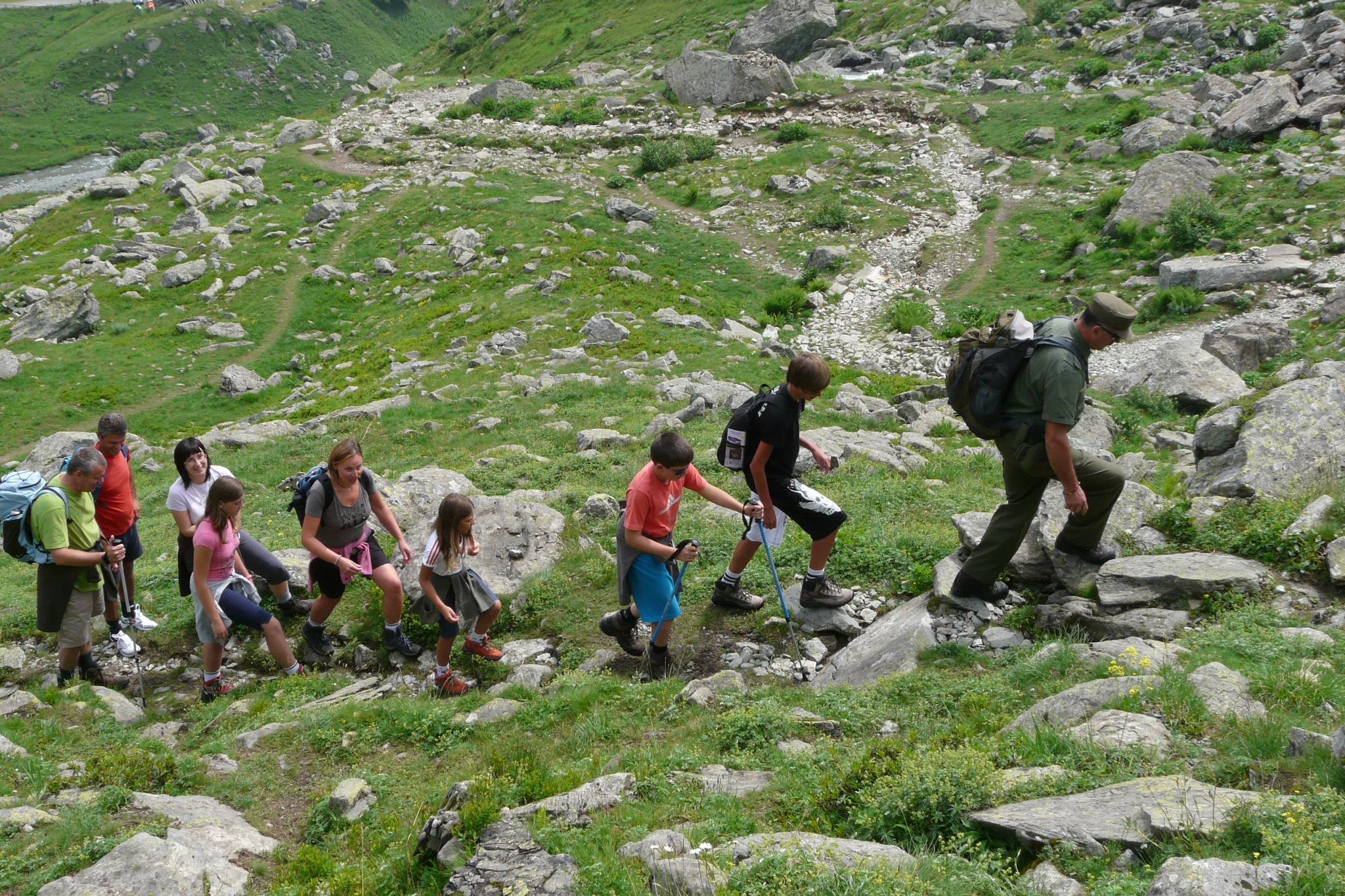 Un guardiaparco guida un gruppo di escursionisti su un sentiero in montagna