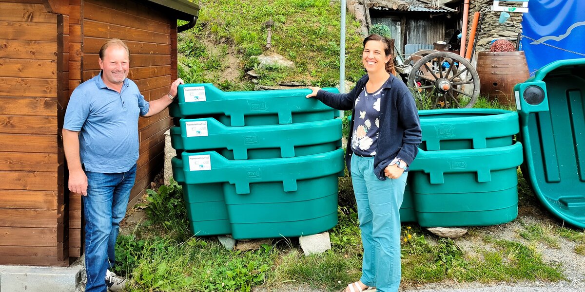 Il presidente del Parco Miretti e la sindaca di Ostana Rovere in piedi con una mano sulle vasche mobili verdi