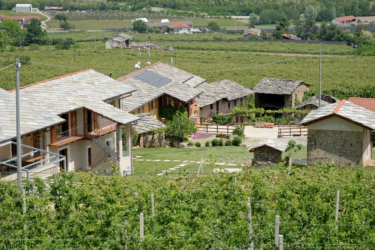 Edifici dell'azienda vista dall'alto con tetti in lose di pietra immersa nel verde