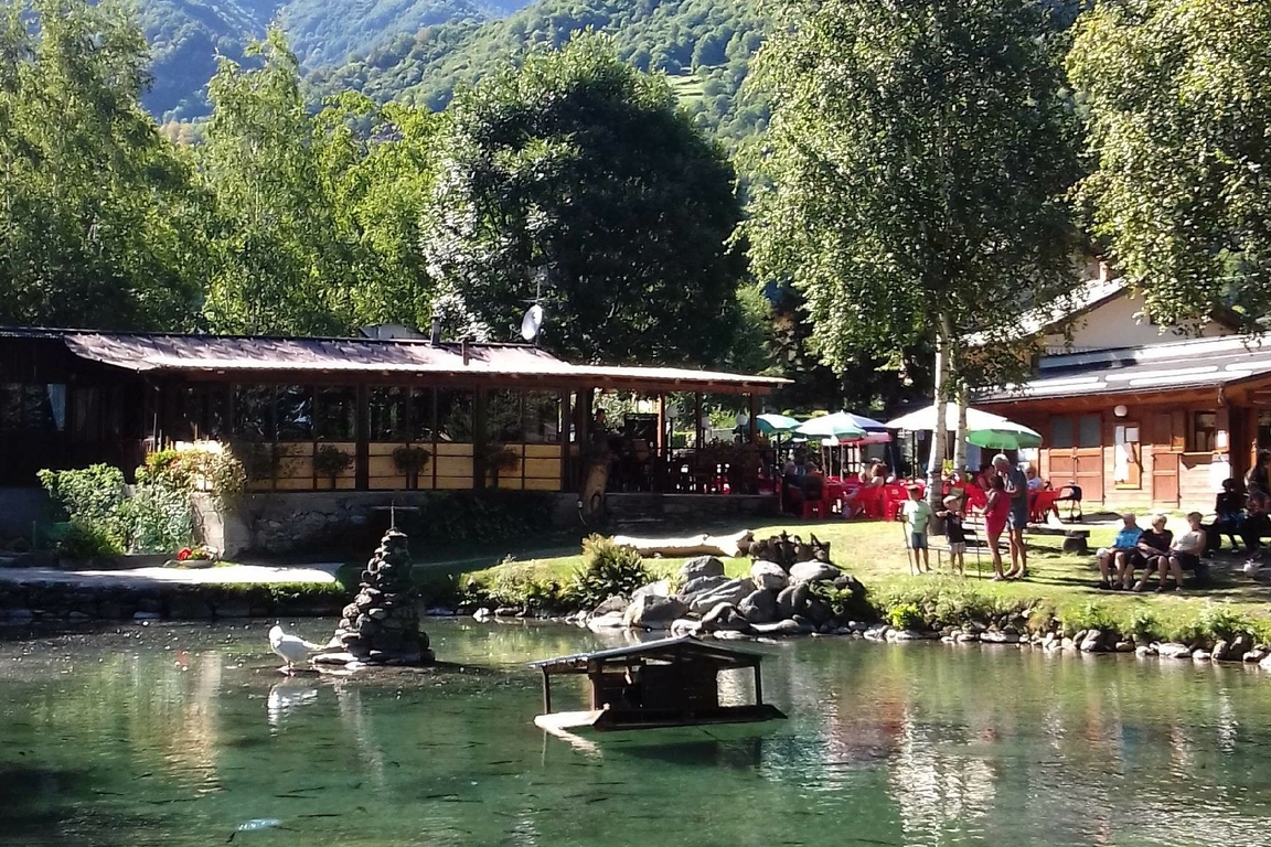 Due immagini affiancate del Lago, una in inverno con la neve (a sinistra) con il lago in primo piano e la costruzione del ristorante sullo sfondo; una in estate dalla stessa prospettiva