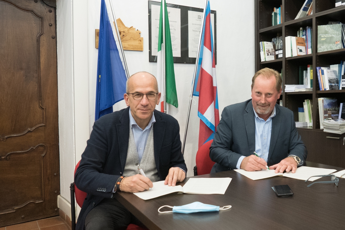il presidente Oderda a sinistra e il presidente Miretti a destra seduti al tavolo firmano il protocollo d'intesa