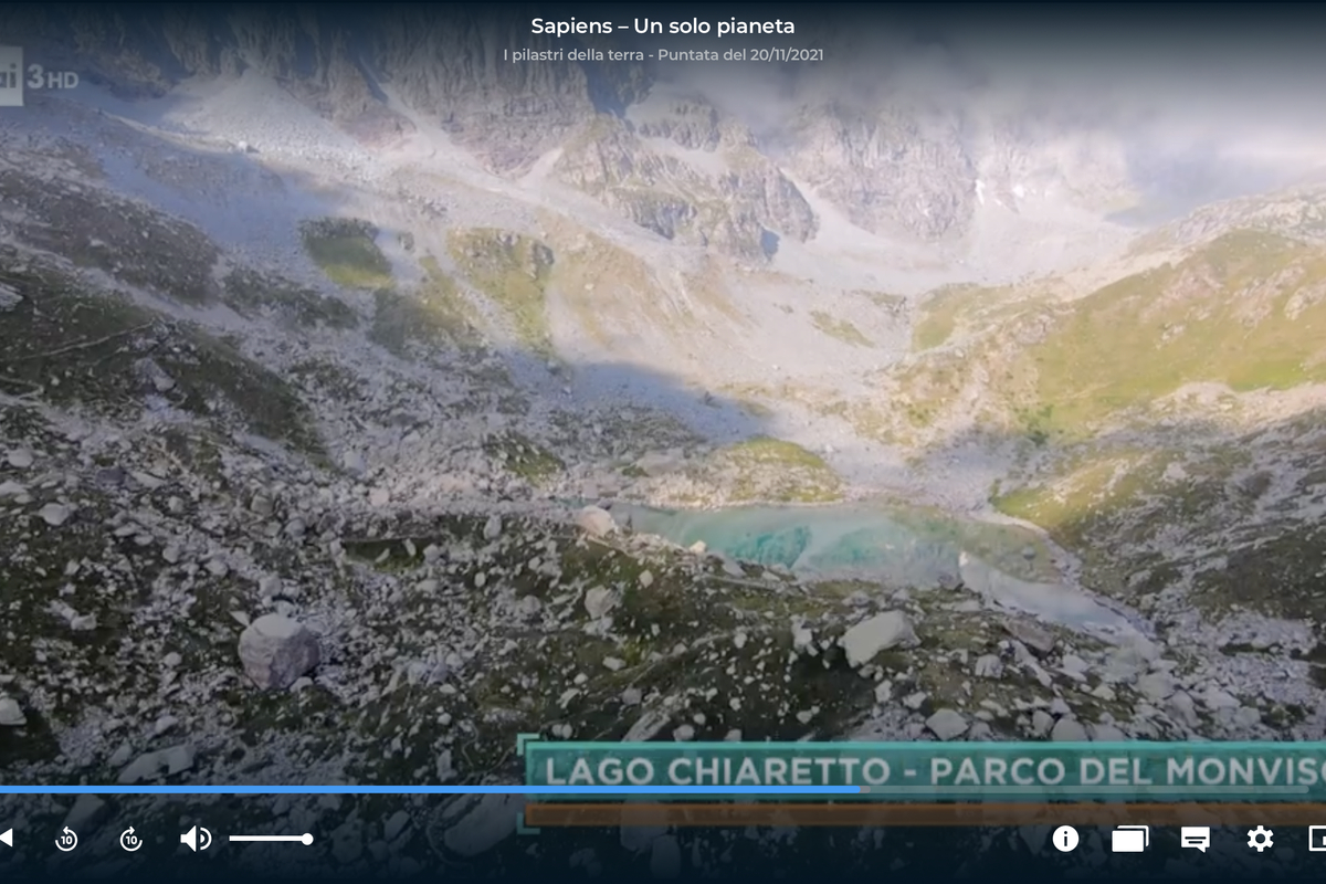 Una schermata della trasmissione Sapiens – Un solo pianeta del 20 novembre 2021 in cui si vede al centro dell'inquadratura il lago Chiaretto, dalle caratteristiche acque color azzurro lattiginoso, circondato dalle rocce ai piedi del Monviso