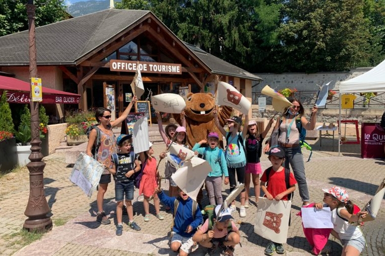 gruppo di bambini con cartelloni e disegni davanti all'ufficio del turismo