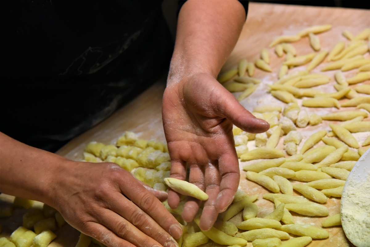 mani che impastano le ravioles, pasta fatta a mano tipo gli gnocchi