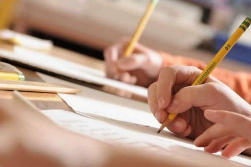Mani che impugnano delle matite e scrivono su dei fogli