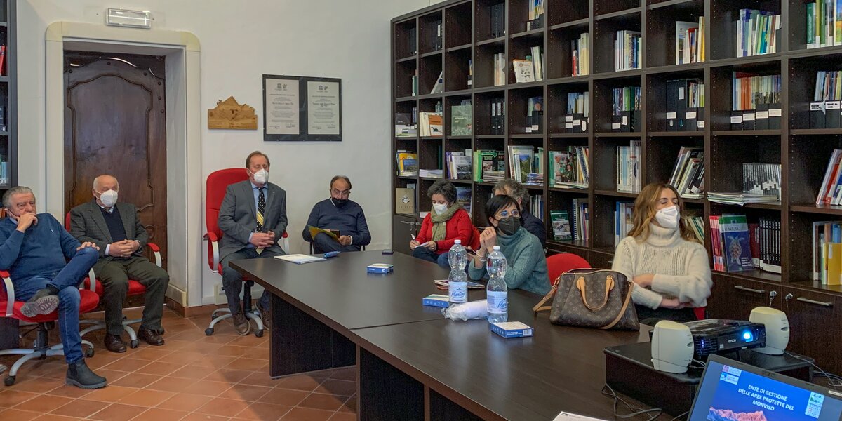 in una sala con una libreria alle pareti i delegati della Regione e i rappresentanti del consiglio del Parco del Monviso, seduto intorno ad una grande tavolo, partecipano alla presentazione dell'Ente