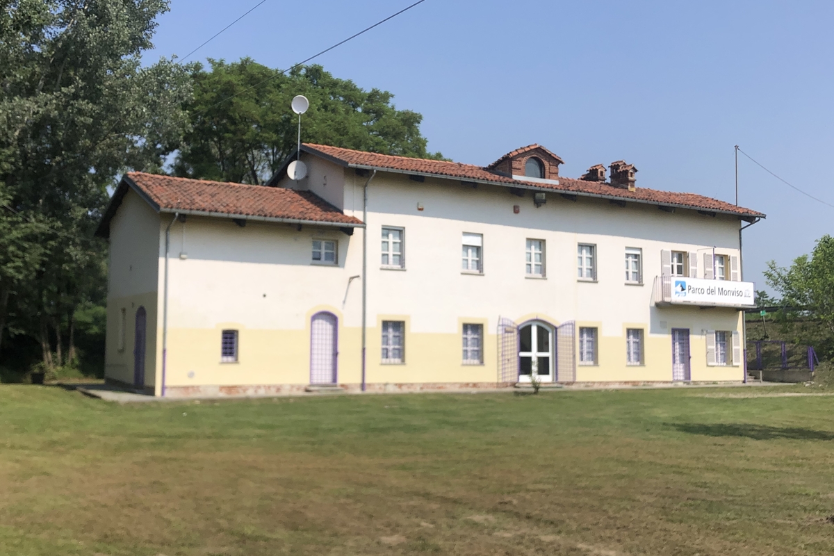 Un prato ben rasato con una struttura sullo sfondo: l'Ostello del Po
