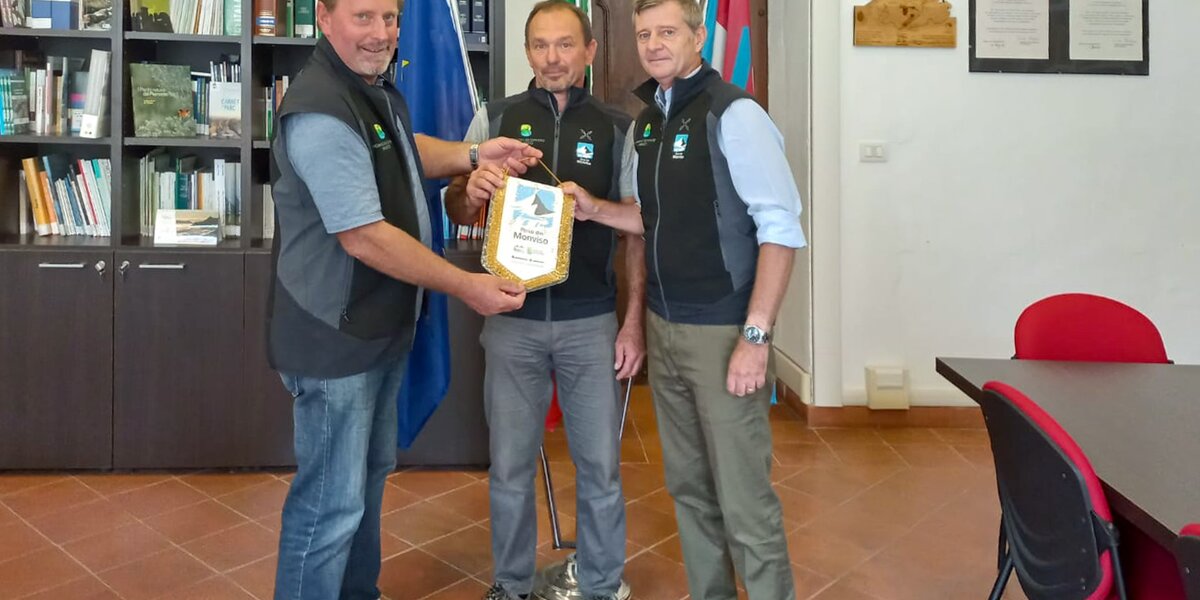 Il Presidente del Parco del Monviso, Dario Miretti, consegna il gagliardetto al Direttore Vincenzo Maria Molinari e al tecnico Mario Giusano.