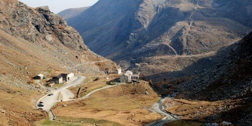 Una veduta autunnale di pian del re con al centro il letto del po, a sinistra il parcheggio e il rifugio di pian del re e intorno prati ingialliti