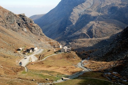Una veduta autunnale di pian del re con al centro il letto del po, a sinistra il parcheggio e il rifugio di pian del re e intorno prati ingialliti
