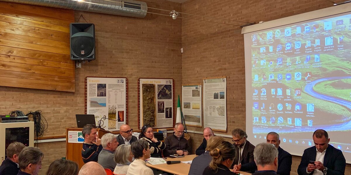 un gruppo di persone intorno a un tavolo, si riconosce l'assessore della Regione Piemonte Fabio Carosso; sulla sinistra della foto, seduti su delle sedie, alcuni direttori dei parchi regionali piemontesi.