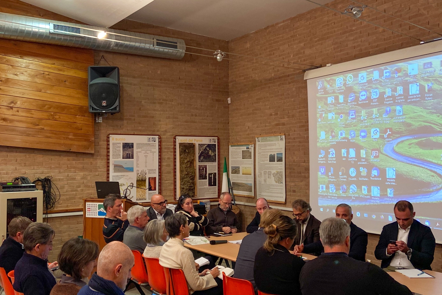 un gruppo di persone intorno a un tavolo, si riconosce l'assessore della Regione Piemonte Fabio Carosso; sulla sinistra della foto, seduti su delle sedie, alcuni direttori dei parchi regionali piemontesi.
