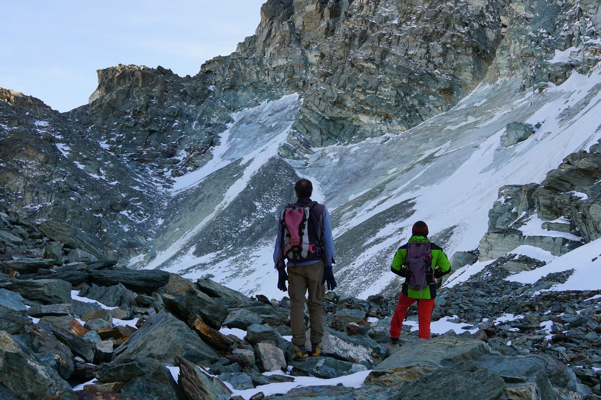 Due persone di spalle, in abito da escursione in montagna, guardano da poche decine di metri di distanza il ghiacciaio Coolidge