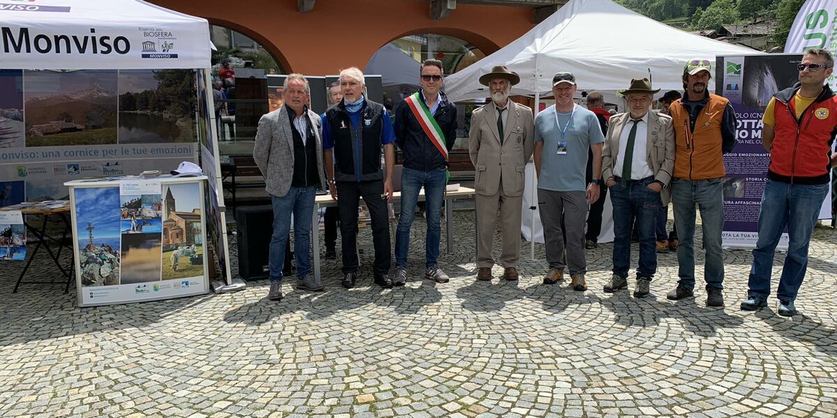 gruppo di persone davanti al Municipio di Crissolo: ai due lati ci sono due gazebo bianchi