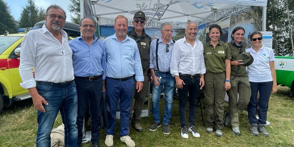 Nove persone davanti al gazebo del Parco del Monviso durante il concerto di ferragosto Monviso Unesco: il terzo da sinistra è il presidente Dario Miretti, il quarto da destra è il Vicepresidente della Regione Piemonte Fabio Carosso.