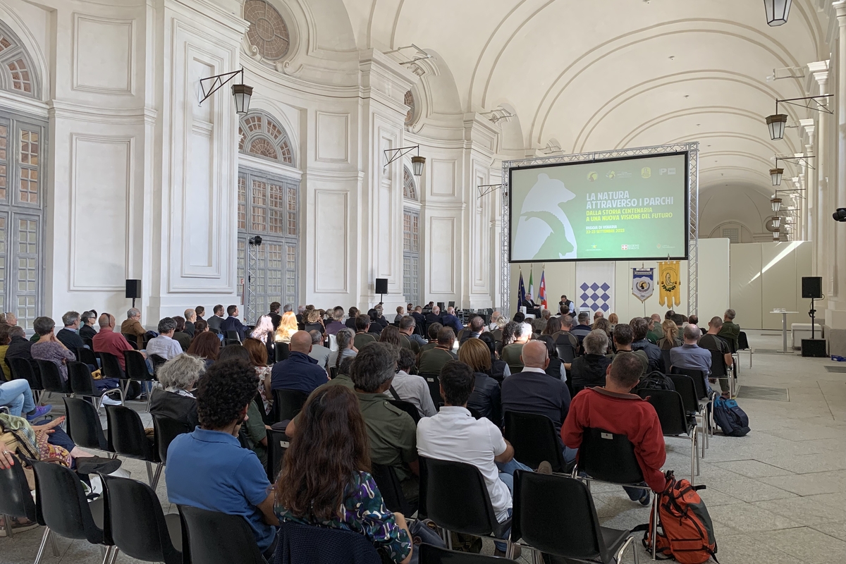 all'interno di una imponente sala (Sala della Citroniera della Reggia della Venaria Reale), molte persone sono sedute di fronte al palco dei relatori.