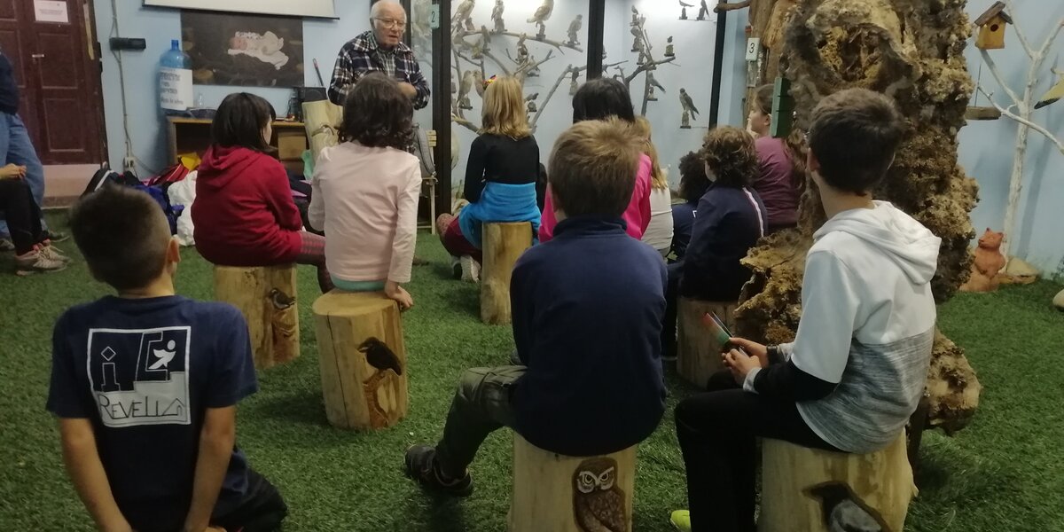Nonno Nino racconta le storie dell'avifauna ad un gruppo di bambini, nella sede della sua mostra permanente.