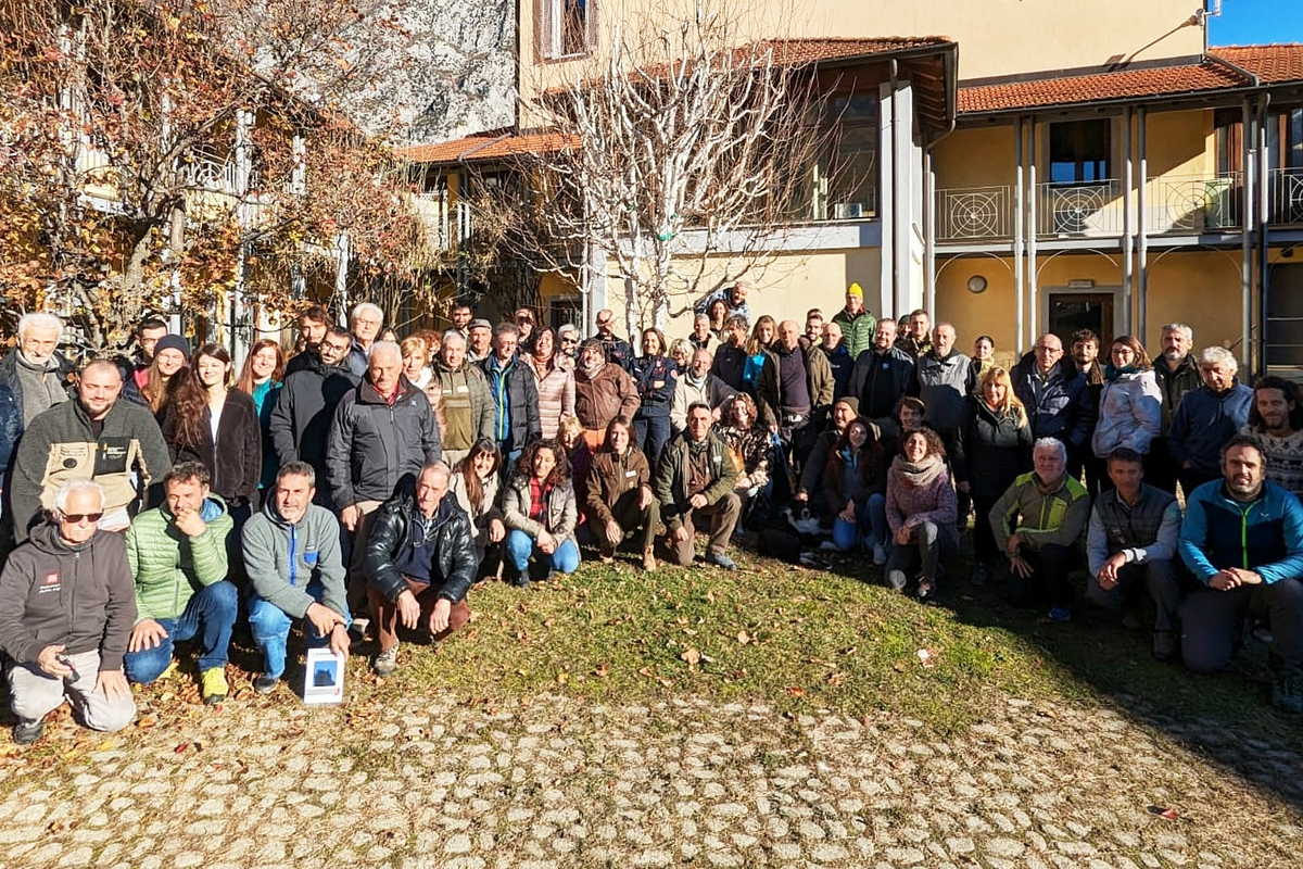 foto di gruppo dei circa 100 partecipanti all'incontro, posti a semicerchio in un'area all'aperto sul retro della sede dell'Ente di Gestione delle Aree protette delle Alpi Marittime