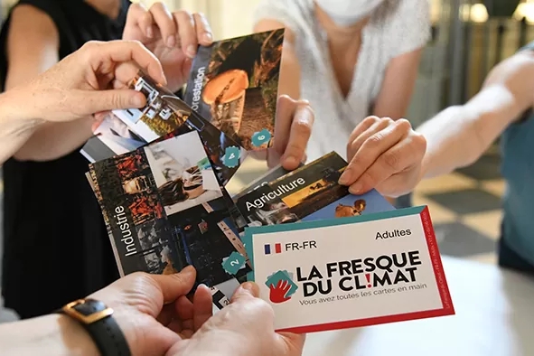 Nell'immagine si vedono alcune mani che tengono delle cartoline che promuovono i laboratori di Fanny.