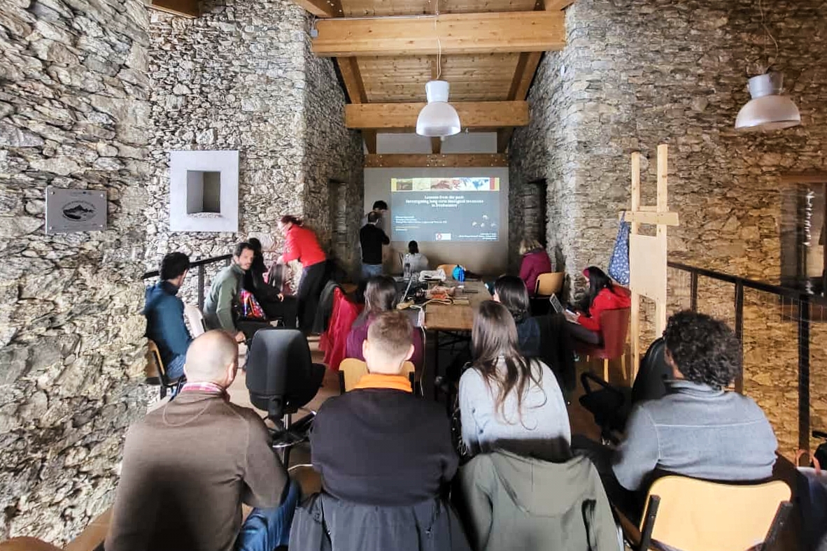 un gruppo di persone sedute di fronte a uno schermo che proietta diapositive di lavoro