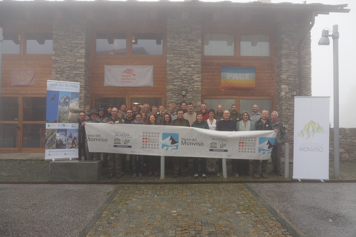 foto di gruppo dei partecipanti, all'aperto e davanti ad un edificio. l'ambiente circostante è grigio, con nebbia e pioggerellina evidenti.