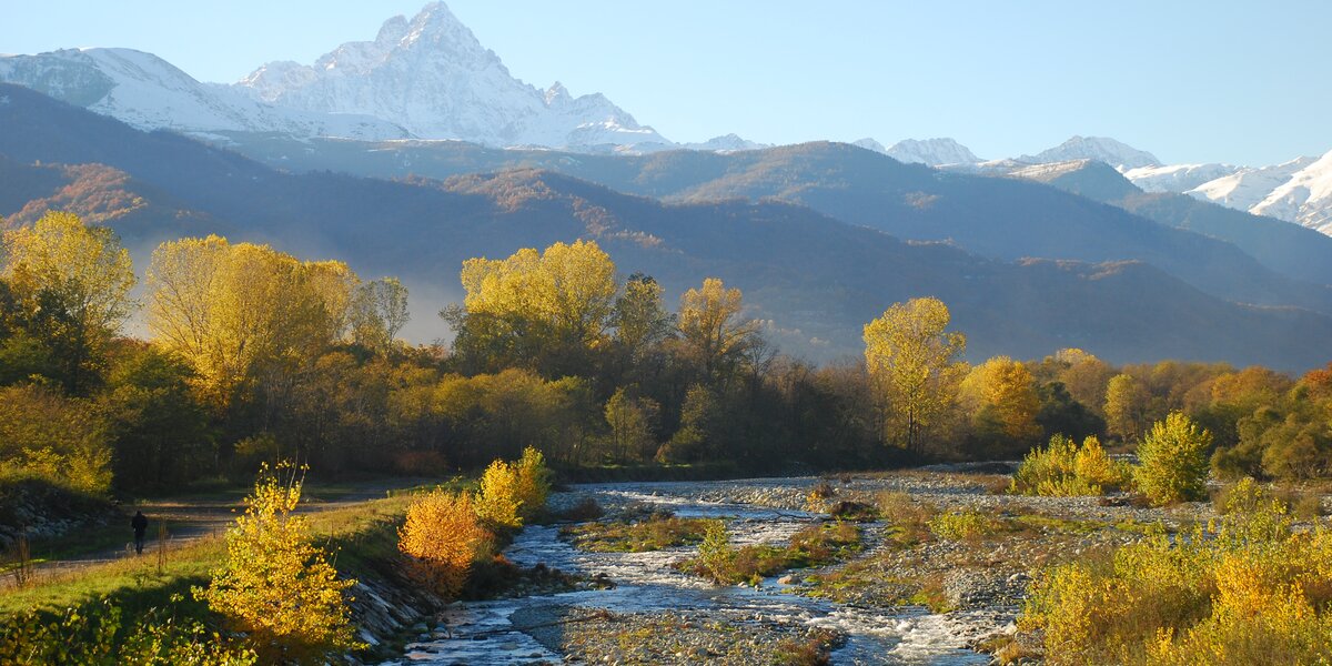 Il Po in primo piano, con qualche isoletta creatasi al centro del greto, ai lati le piante e sullo sfondo il Monviso
