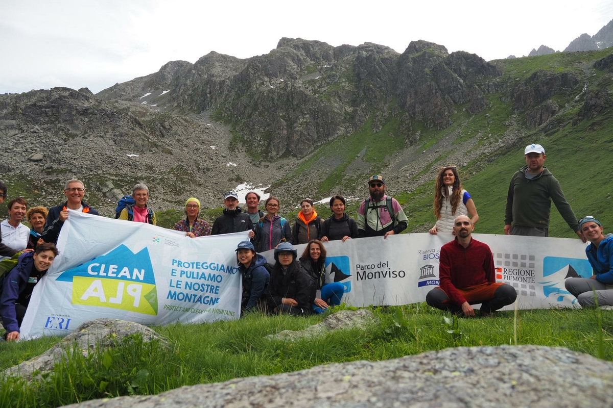 foto di gruppo dei partecipanti a una delle due escursioni citate nel testo. I partecipanti sorreggono gli striscioni dell'iniziativa, quello di CleanAlp e quello del Parco del Monviso.