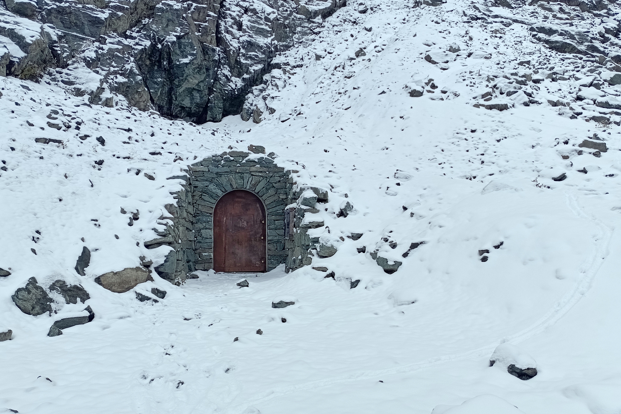 l'imboccatura francese del Buco di Viso chiusa. Intorno al tunnel il paesaggio è ricoperto di un leggero strato di neve.