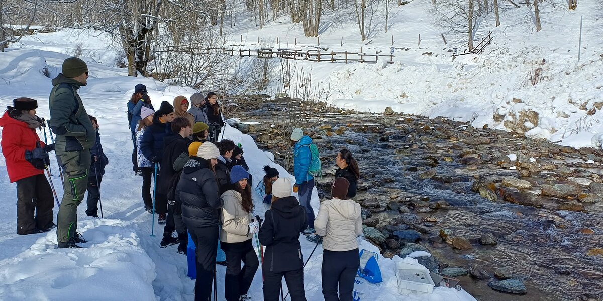 studenti e accompagnatori sul greto del fiume Po in un momento di didattica sul campo. l'ambiente è innevato e tutti hanno abbigliamento invernale.
