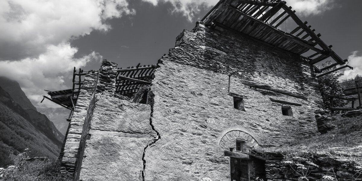foto in bianco e nero di una casa di montagna abbandonata
