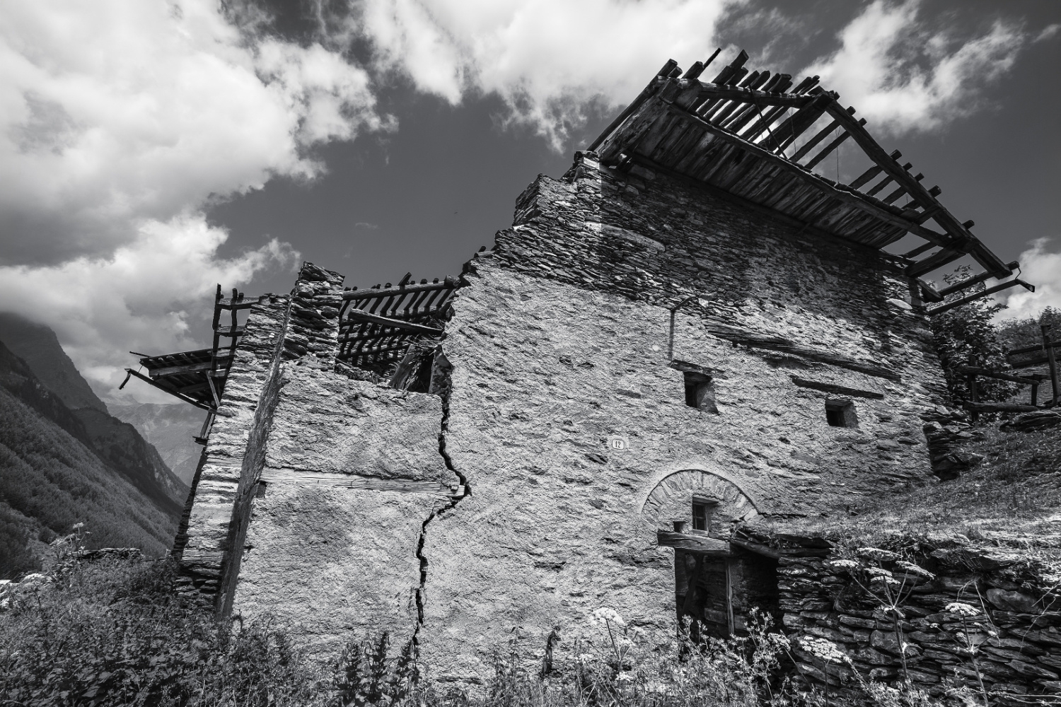 foto in bianco e nero di una casa di montagna abbandonata